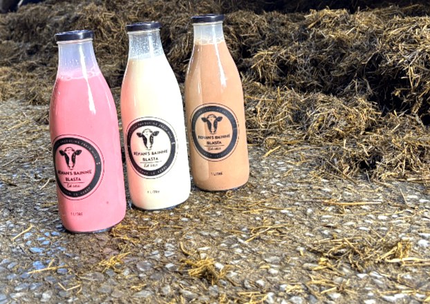 Close-up of three Behan's Bainne Blasta bottles showing the cow logo and pink, cream and chocolate flavours